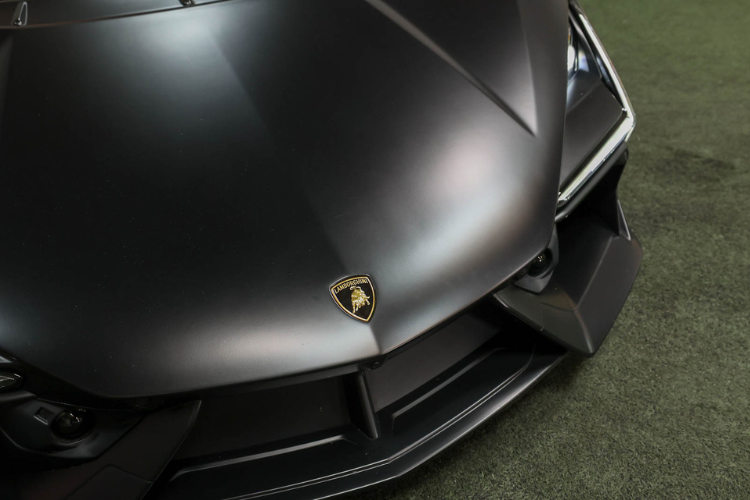 Close-up of Lamborghini badge on black Revuelto