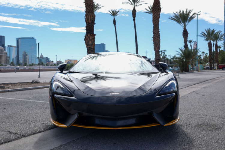 Front view of a custom-wrapped McLaren 570S Spider showcasing its sleek headlights and yellow accents in Las Vegas.