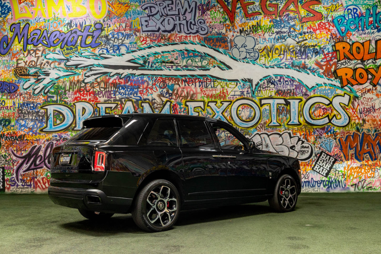 Rear three-quarter view of a black Rolls-Royce Cullinan rental