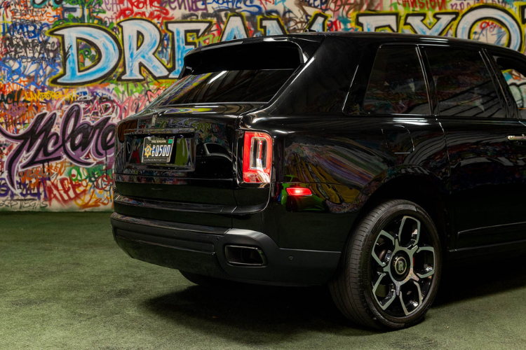 Close rear-side view of a black Rolls-Royce Cullinan luxury SUV
