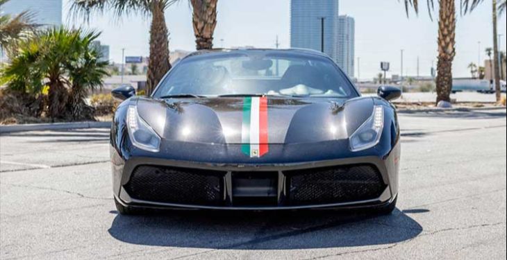 Front view of a luxury Ferrari with the Las Vegas strip in the background.