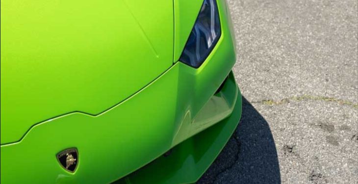 Front hood and light portion of a neon green lamborghini huracan.