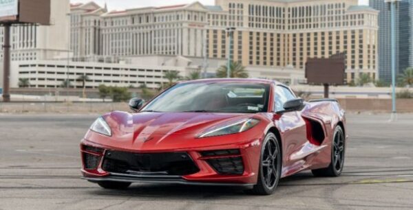 A red Chevy Corvette C8 being shown off in front of Caesar's Palace in Las Vegas.