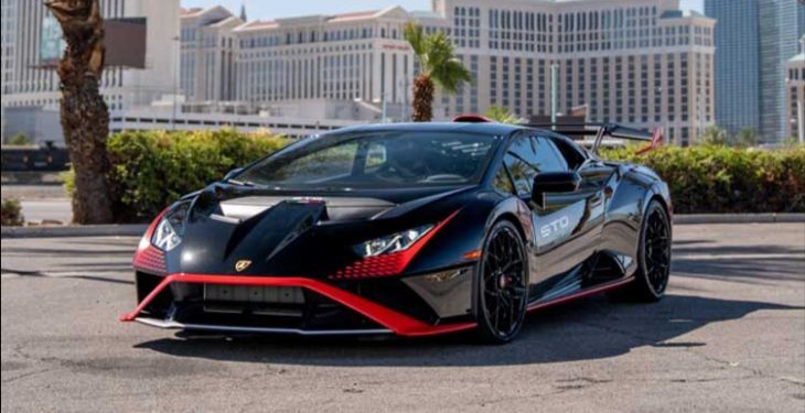 Black exotic car with red detailing against a backdrop of the Las Vegas Strip.